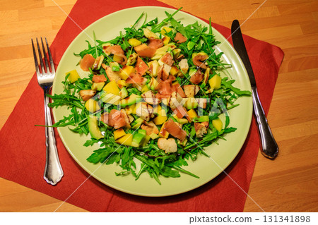 Fresh healthy salad with mango, avocado, salmon, arugula and croutons on wooden table 131341898