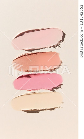Four smears of cosmetic products in various shades of pink, peach, and beige are displayed on a beige background, creating a visually appealing arrangement of textures and colors Four smears of cosmetic products in various shades of pink, peach, and beige are displayed on a beige background, creating a visually appealing arrangement of textures and colors 131342552