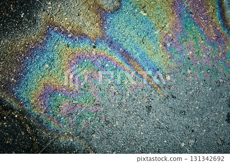 Oil slick on asphalt creating a colorful psychedelic rainbow pattern of iridescent sheen 131342692