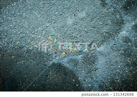 Iridescent oil slick creating colorful abstract pollution on wet asphalt 131342698