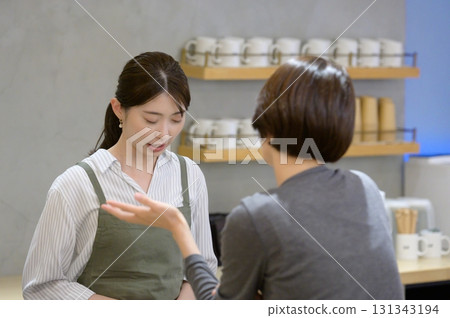 A woman complaining to a cafe staff member 131343194