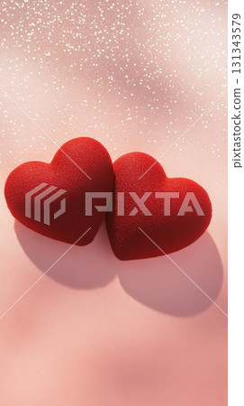 Two textured red hearts lie on a pink surface, casting shadows under a romantic shower of sparkling glitter, creating a perfect scene for valentine's day or a declaration of love 131343579