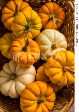 Autumn pumpkins background. Orange and white mini squashes in a basket, rustic style. 131343841
