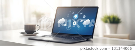 Laptop with cloud computing and social media icons in a bright home office, showcasing technology and online networking with a nearby coffee cup 131344066