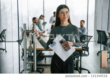 Young woman in glasses, portrait. Team of office workers are together indoors 131344516