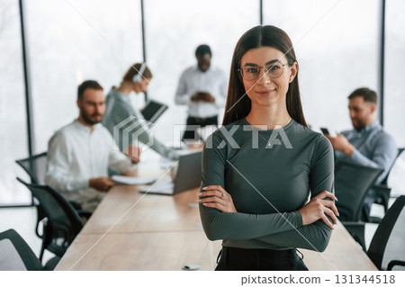 Young woman in glasses, portrait. Team of office workers are together indoors 131344518