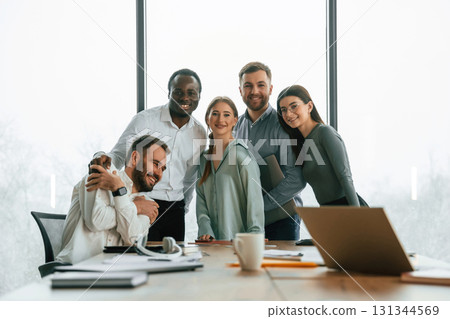 Posing for the camera. Team of office workers are together indoors 131344569