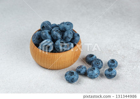 Fresh ripe blueberries in wooden bowl on light gray stone background closeup macro healthy food Fresh ripe blueberries in wooden bowl on light gray stone background closeup macro healthy food 131344986