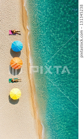Tourists are relaxing on pink beach towels under colorful beach umbrellas on a sunny day, with crystal clear turquoise water gently lapping the shore, promoting sustainable tourism 131345238