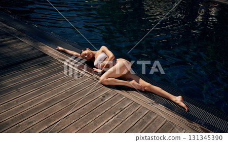 Near swimming pool. Woman in white bikini 131345390