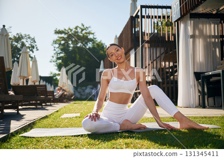 Against exterior of the recreation complex. Young woman in fitness clothes is outdoors 131345411