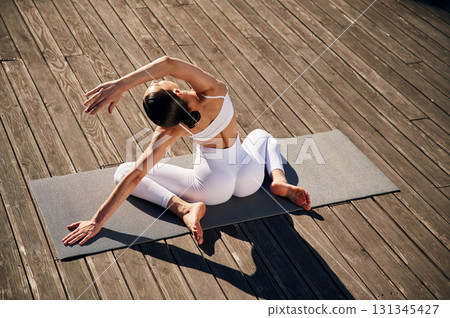 Professional yoga practitioner. Young woman in fitness clothes is outdoors Professional yoga practitioner. Young woman in fitness clothes is outdoors 131345427