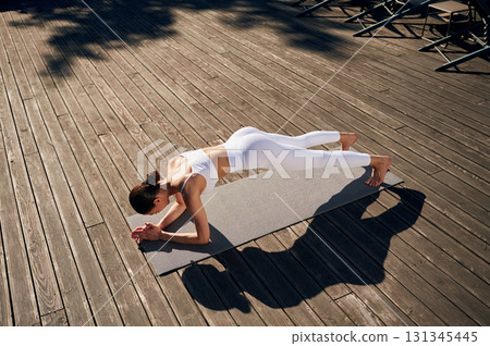 Plank exercise. Young woman in fitness clothes is outdoors Plank exercise. Young woman in fitness clothes is outdoors 131345445