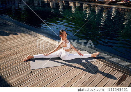 Makes twine. Young woman in fitness clothes is outdoors 131345461