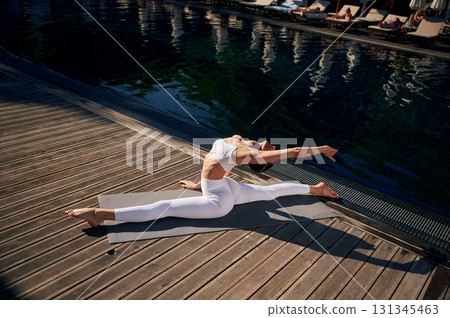 Makes twine. Young woman in fitness clothes is outdoors 131345463