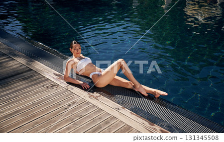 Near swimming pool. Woman in white bikini 131345508