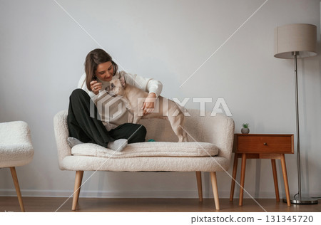 Young woman is with her pug dog at home 131345720