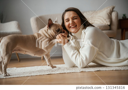 Young woman is with her pug dog at home 131345816