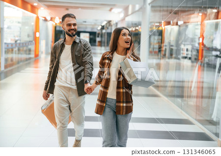 In the mall with clothes. Young couple are in supermarket together In the mall with clothes. Young couple are in supermarket together 131346065