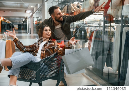 Having fun, riding in the cart. Young couple are in supermarket together 131346085