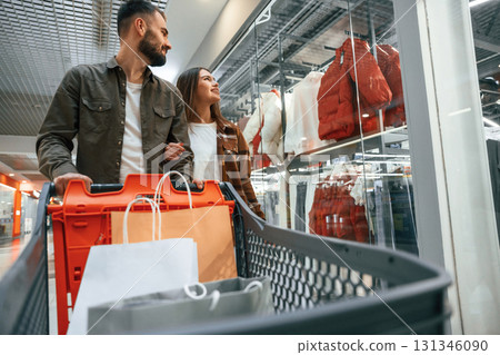 Many of the clothes on the side. Young couple are in supermarket together 131346090