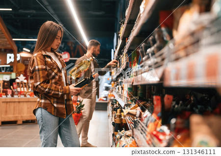 Oil in hands. Young couple are in supermarket together 131346111