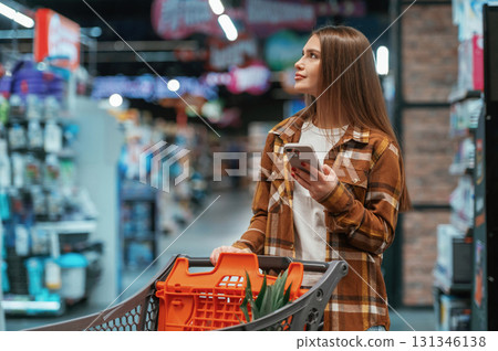Looking for products. Woman is shopping in the supermarket 131346138