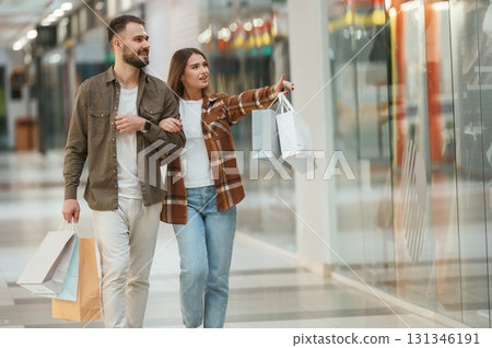 Walking, looking at products. Young couple are in supermarket together Walking, looking at products. Young couple are in supermarket together 131346191