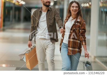 Guy don't want to go for shopping. Young couple are in supermarket together Guy don't want to go for shopping. Young couple are in supermarket together 131346220