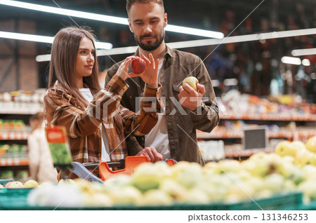 Bunch of products. Young couple are in supermarket together Bunch of products. Young couple are in supermarket together 131346253