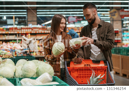 Bunch of products. Young couple are in supermarket together 131346254
