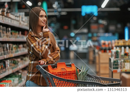 Looking for products. Woman is shopping in the supermarket 131346313