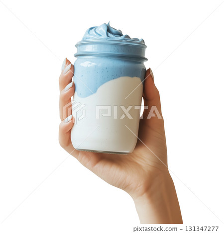 Hand holding a jar of blue yogurt smoothie, isolated on a transparent background. 131347277