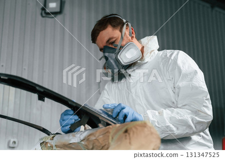 Metal carcass. Repairman is working in the garage Metal carcass. Repairman is working in the garage 131347525