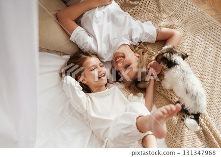 Cute dog is with them. Mother with daughter are at home together Cute dog is with them. Mother with daughter are at home together 131347968