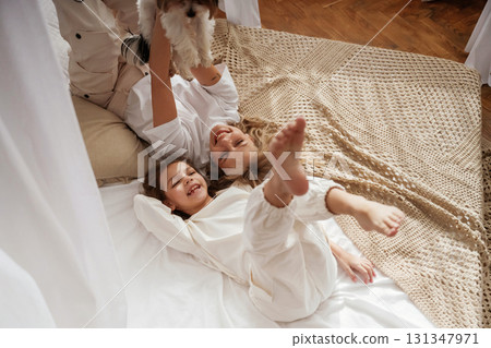 Dog pet is with them. Mother with daughter are at home together Dog pet is with them. Mother with daughter are at home together 131347971