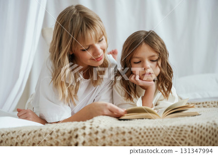 Reading the book together. Mother with daughter are at home 131347994