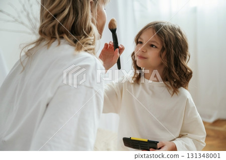 Doing make up. Mother with daughter are at home together 131348001