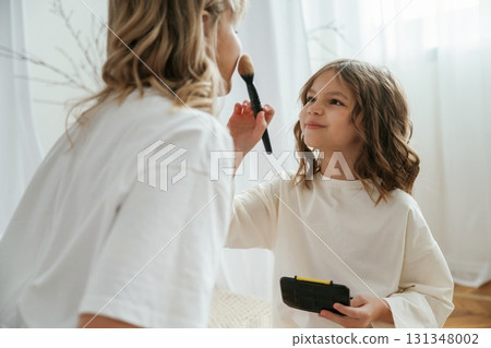 Doing make up. Mother with daughter are at home together 131348002