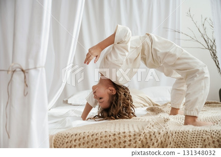 Playing on the bed. Cute little girl is at home Playing on the bed. Cute little girl is at home 131348032