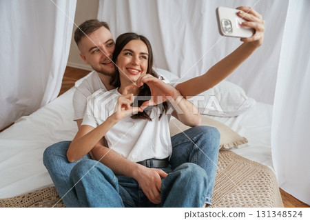 Using smartphone for selfie. Young couple are together at home Using smartphone for selfie. Young couple are together at home 131348524