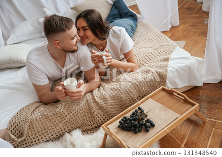 With cup and grape. Young couple are together at home 131348540