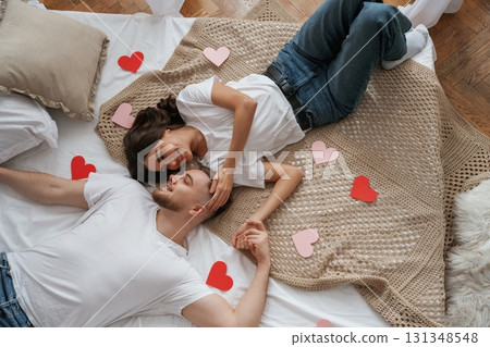 A lot of heart shaped paper decorations, top view. Young couple are together at home A lot of heart shaped paper decorations, top view. Young couple are together at home 131348548