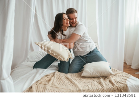 Soft pillows are in hands, playing. Young couple are together at home 131348591