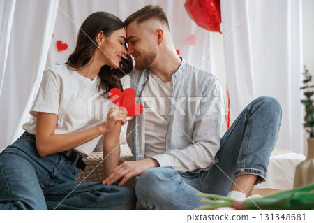 Holding paper hearts. Young couple are together at home 131348681