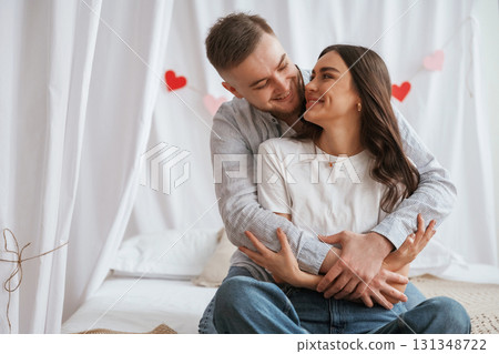 Festive decorations, Valentine's day. Young couple are together at home Festive decorations, Valentine's day. Young couple are together at home 131348722