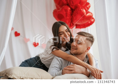 Bunch of heart shaped balloons, celebrating. Young couple are together at home Bunch of heart shaped balloons, celebrating. Young couple are together at home 131348743