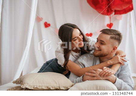 Bunch of heart shaped balloons, celebrating. Young couple are together at home Bunch of heart shaped balloons, celebrating. Young couple are together at home 131348744