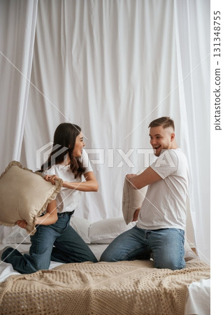 Pillow fight. Young couple are together at home Pillow fight. Young couple are together at home 131348755