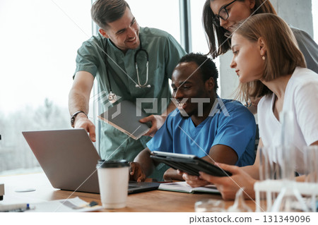 Reading information from laptop. Group of doctors are together indoors 131349096